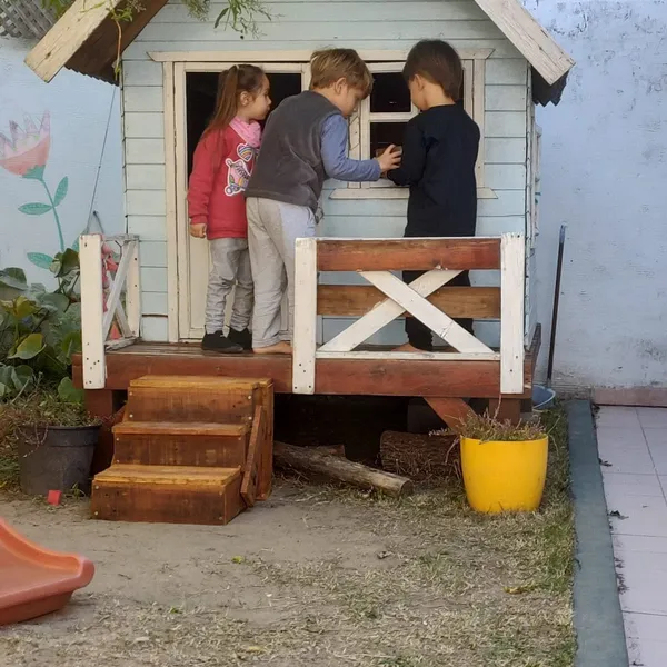 Niños jugando en la casita del patio